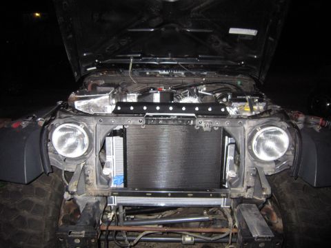 2008 Jeep Wrangler - Jeep Wrangler engine bay with hood open, revealing a large radiator and custom engine modifications.
