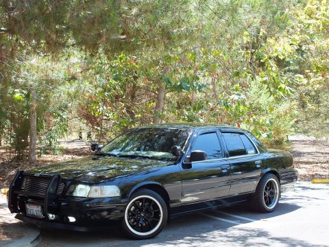 2003 Ford Crown Victoria - Police Interceptor with grille guard and tinted glass parked, front California plate visible