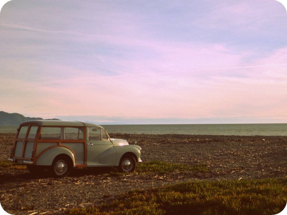 Wood-paneled station wagon parked by the ocean