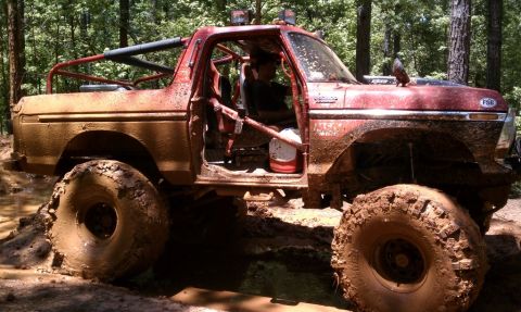1979 Ford F-150 - This heavily modified truck is deep in the mud, showing off its off-road capabilities.