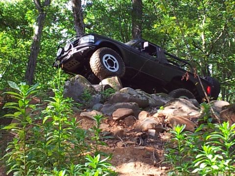 1979 Ford F-150 - Truck navigating a rocky obstacle on an off-road trail.