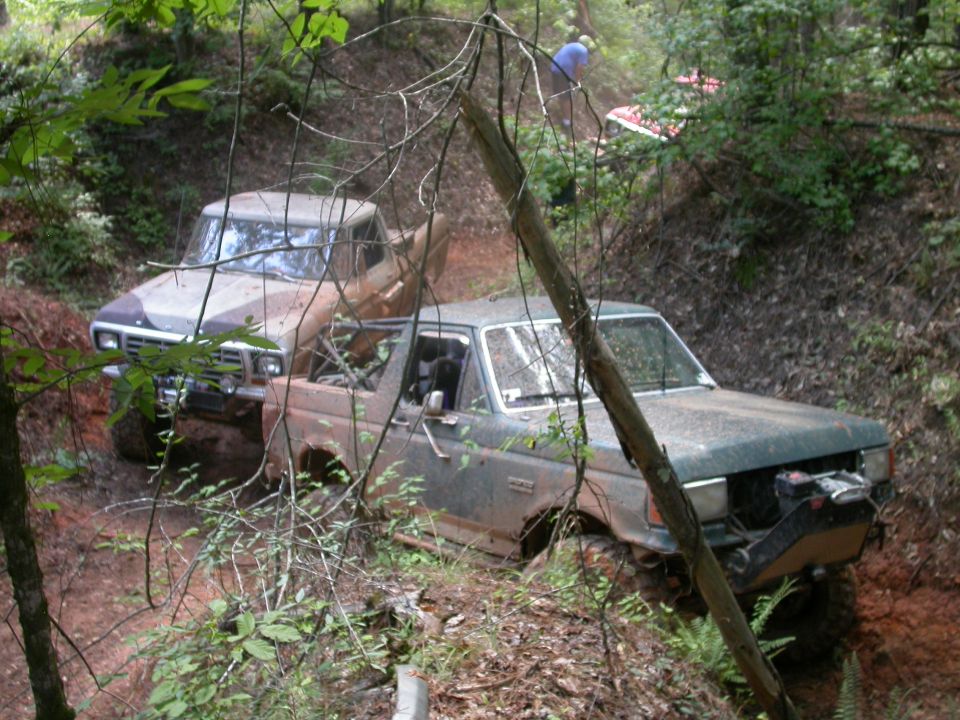 1979 Ford F-150 and another truck on a muddy trail