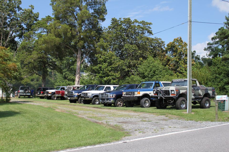 Camouflaged Ford pickup truck with lifted suspension and off-road tires parked on grass