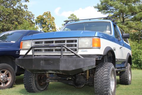 1994 Ford Bronco - This 1994 Ford Bronco features a custom front bumper and roof rack, seen parked next to another vehicle.