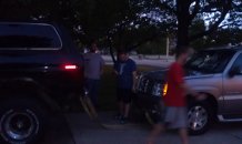 1979 Ford Bronco - A dark SUV is parked next to other vehicles under trees at dusk.