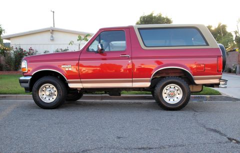 1994 Ford Bronco - This 1994 Ford Bronco is shown from the side, its iconic red paint and tan removable top.