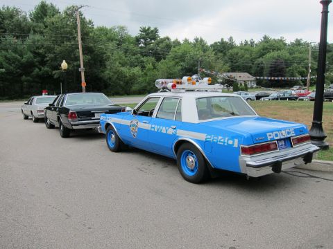 1991 Ford LTD Crown Victoria - Rear three-quarter view of a blue NYPD Highway Patrol sedan numbered 2640 parked behind other vintage cruisers.