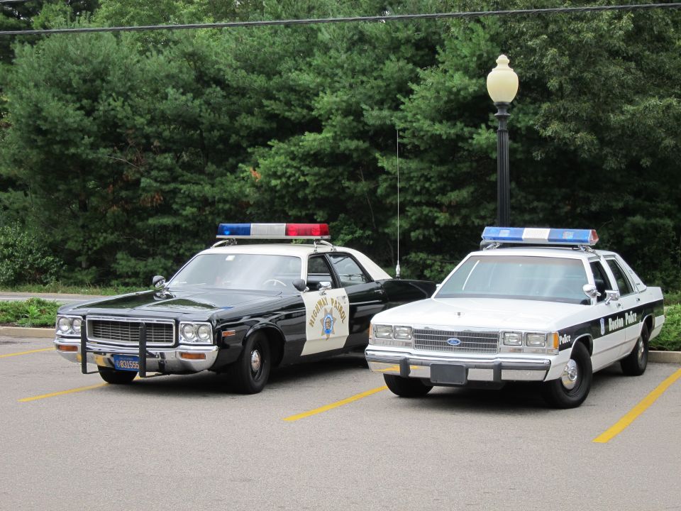 Black-and-white CHP-style sedan beside a white-and-black police cruiser