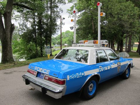 1991 Ford LTD Crown Victoria - Rear three-quarter view of a blue NYPD Highway police sedan with tall pole-mounted lights and POLICE HWY 3 markings.