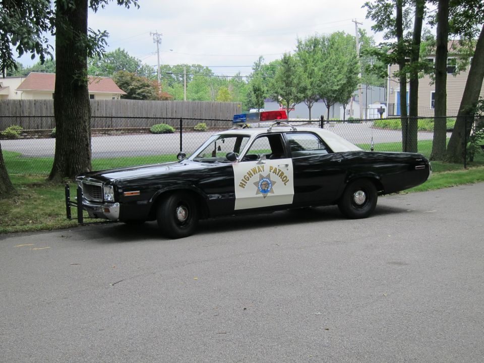 Black and white California Highway Patrol sedan, front three-quarter view