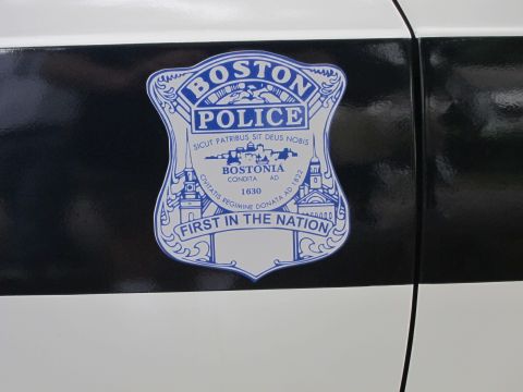 1991 Ford LTD Crown Victoria - Close-up of a Boston Police shield decal reading 'First in the Nation' on a black and white vehicle door panel.