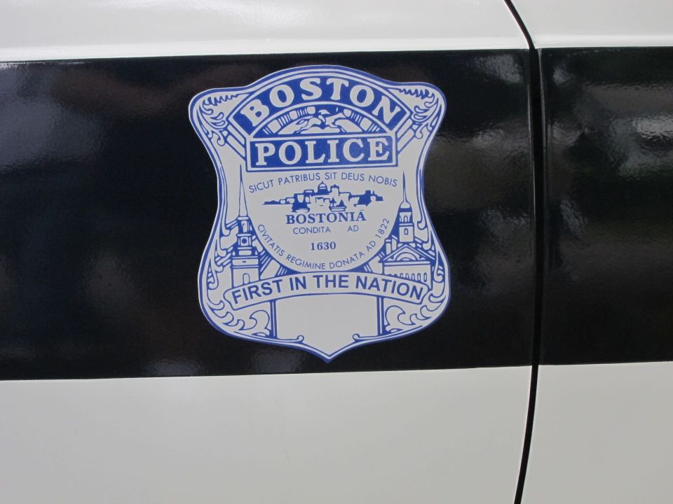 Blue and white Boston Police badge decal on a black-and-white car door