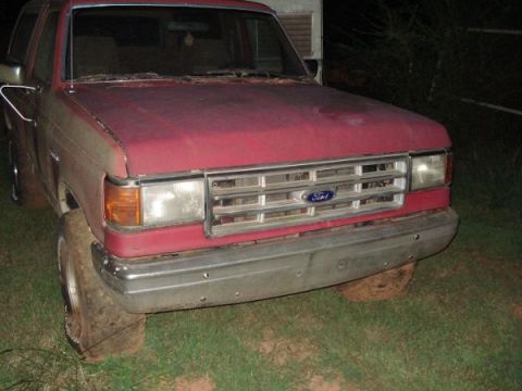 1995 Ford Bronco - This 1995 Ford Bronco features a prominent chrome grille and a red exterior, seen from the front.