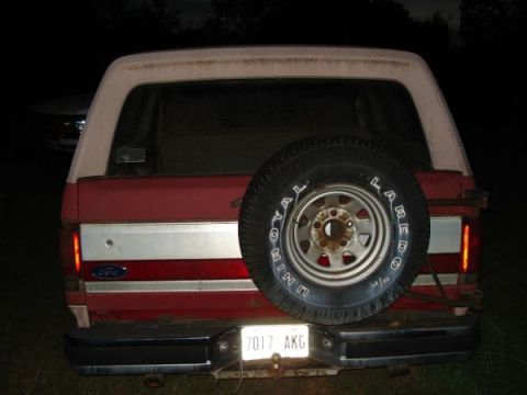 1995 Ford Bronco - Rear view of a red 1995 Ford Bronco, a spare tire mounted on the tailgate and a visible license plate.