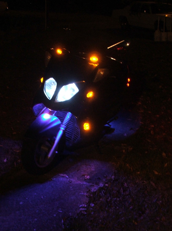 Scooter front view with illuminated headlights and orange turn signals
