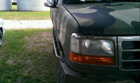 1995 Ford Bronco - This Ford truck features a camouflage paint job and a side step.