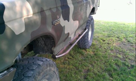1995 Ford Bronco - Camouflaged 1995 Ford Bronco equipped with side rock sliders and off-road tires.