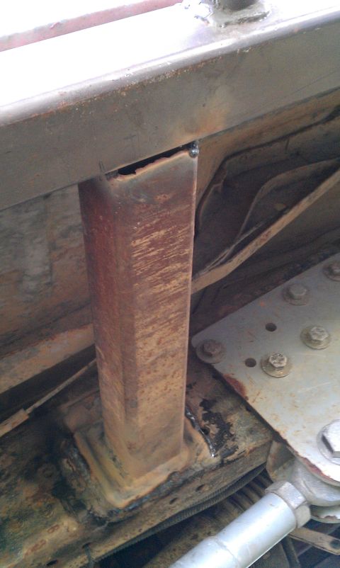 1995 Ford Bronco - Undercarriage view of a rusted metal bracket, likely part of a rock slider assembly.
