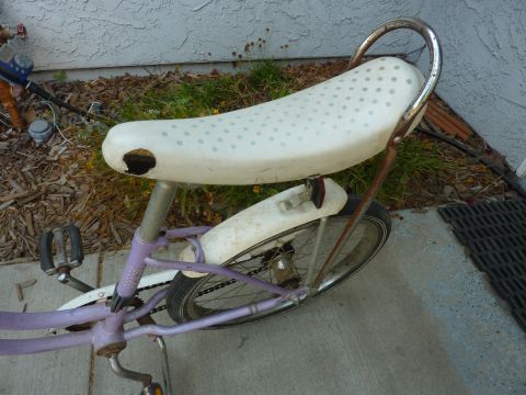 1900 Yugo GVX - Close-up of a bicycle's rear wheel and seat, showing a white polka-dot seat and purple frame.