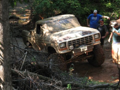 1979 Ford F-150 - This heavily muddied 1979 Ford F-150 navigates a challenging off-road course with onlookers present.