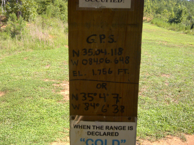 Wooden post shows GPS coordinates and elevation. Also has text about range status
