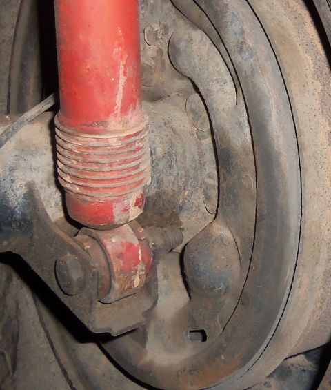 1968 Ford Bronco - Close-up of a vehicle's rear drum brake assembly and red shock absorber, with Supermotors.net branding visible.