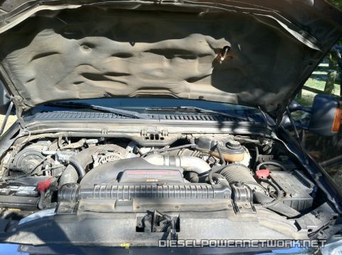 2003 Ford F-250 - The engine bay of a 2003 Ford F-250 is shown, with the "Power Stroke V8 Turbo Diesel" label clearly visible on the engine cover.