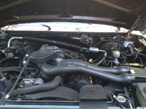 1991 Ford Bronco - The engine bay of a 1991 Ford Bronco is visible with the hood open.
