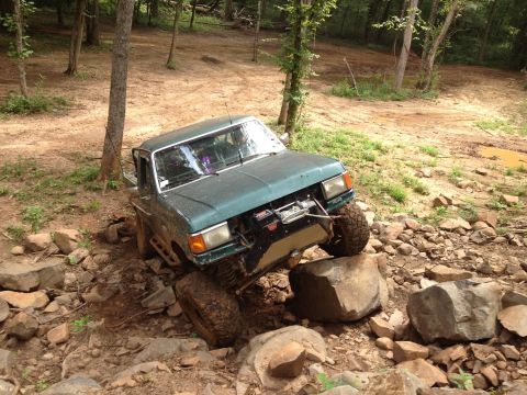 1979 Ford F-150 - Pickup truck attempting to climb over large rocks on an off-road trail.