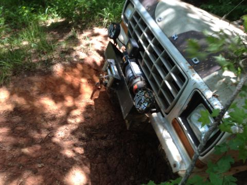 1979 Ford F-150 - Front view of a 1979 Ford F-150 truck with a winch, stuck in mud.