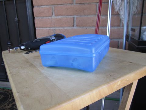 1963 Ford Falcon - A blue plastic container sits on a wooden table next to a rotary tool and a broom.