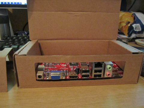 1963 Ford Falcon - A computer motherboard's rear ports are exposed through a custom-cut opening in a cardboard box.