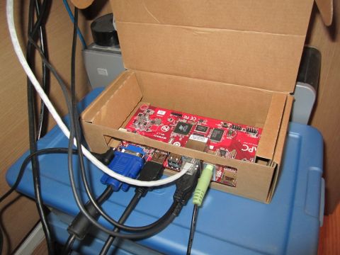 1963 Ford Falcon - Computer circuit board with VGA, USB, and audio cables connected, resting in a cardboard box.