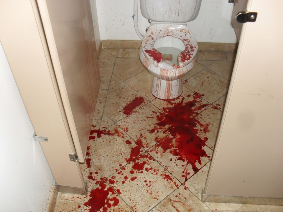 Bathroom floor and toilet covered in blood splatters