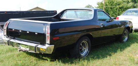 1975 Ford Ranchero - Rear view of a black 1975 Ford Ranchero parked on grass.