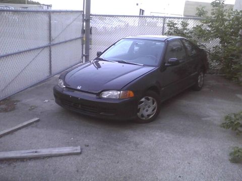 2003 Ford Crown Victoria - This black coupe is parked on concrete, seen from a 3/4 front angle.