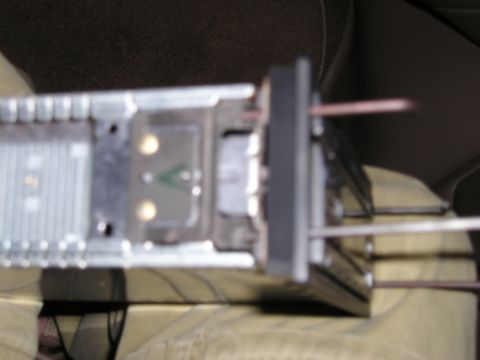 1996 Ford Bronco - Close-up of a car stereo being installed, showing the mounting bracket and wiring.