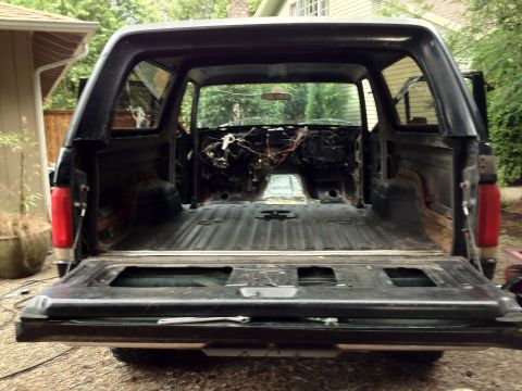 1987 Ford Bronco - The interior of this 1987 Ford Bronco has been gutted, revealing the bare metal cargo area and exposed wiring.