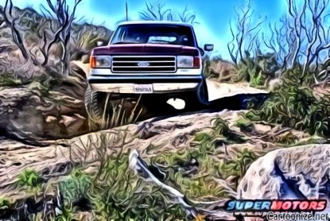1990 Ford Bronco - This 1990 Ford Bronco navigates a , off-road path under a bright blue sky.