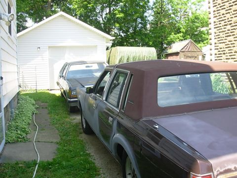 1988 Lincoln Town Car - A 1988 Lincoln Town Car is parked in a driveway next to another vehicle.
