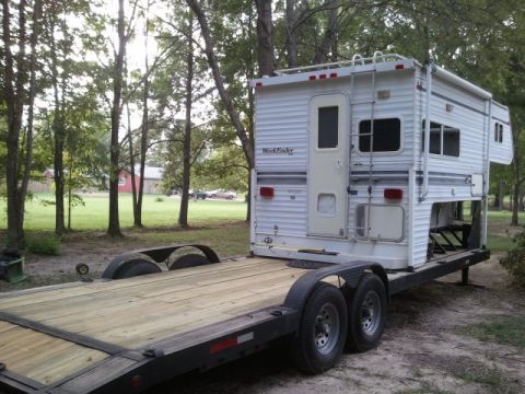 1967 Ford Mustang - Tandem-axle flatbed trailer with a fresh wood deck and steel frame, mounted with a white 'WeekEnder' slide-in truck camper over the goosene…