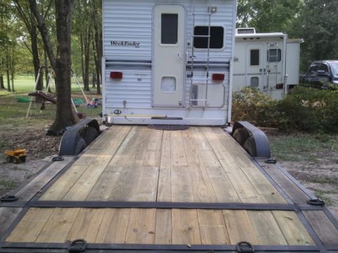 1967 Ford Mustang - A toy hauler camper is parked on a flatbed trailer, with another camper and a truck visible in the background.