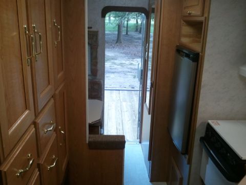 1967 Ford Mustang - View from inside an RV hallway, showing cabinets, a fridge, and the outdoors through an open door.