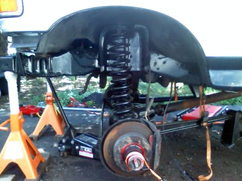 1993 Ford F-150 - Vehicle suspension components are visible, supported by jack stands and a floor jack during maintenance.