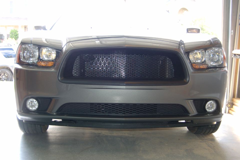 Front view of a gray Dodge Charger with a black mesh grille and fog lights