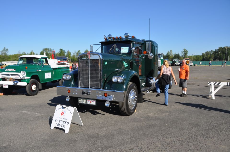 1959 Kenworth W900A and a green GMC pickup truck parked at an outdoor show