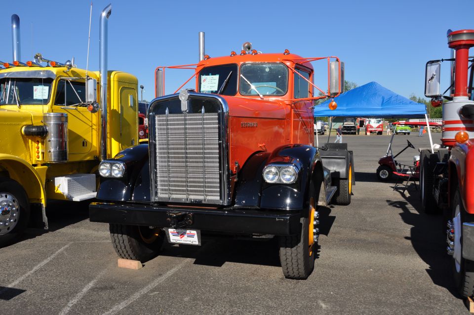 Orange and black 1959 Kenworth W900A semi-truck front view with chrome grille