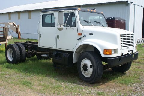 2000 Jeep Wrangler - This white crew cab truck chassis is presented from a three-quarter front view, showing its dual rear wheels and bare frame.