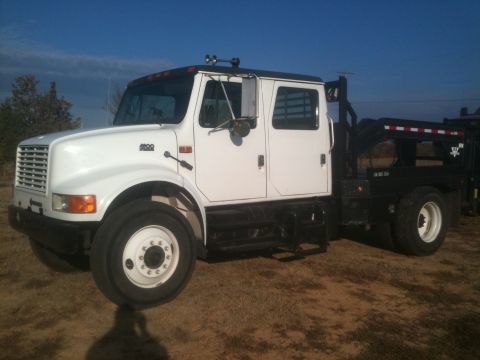 2000 Jeep Wrangler - This white crew cab flatbed truck has a '4000' badge on the fender and appears to be an International model.