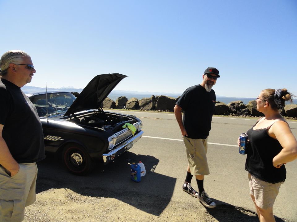 Black 1964 Ford Fairlane convertible with hood open, parked roadside